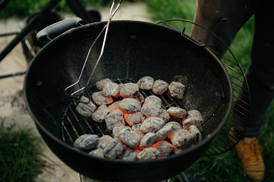 Poignée de pellets de bois destinés à un barbecue, prêts à être versés dans la trémie.