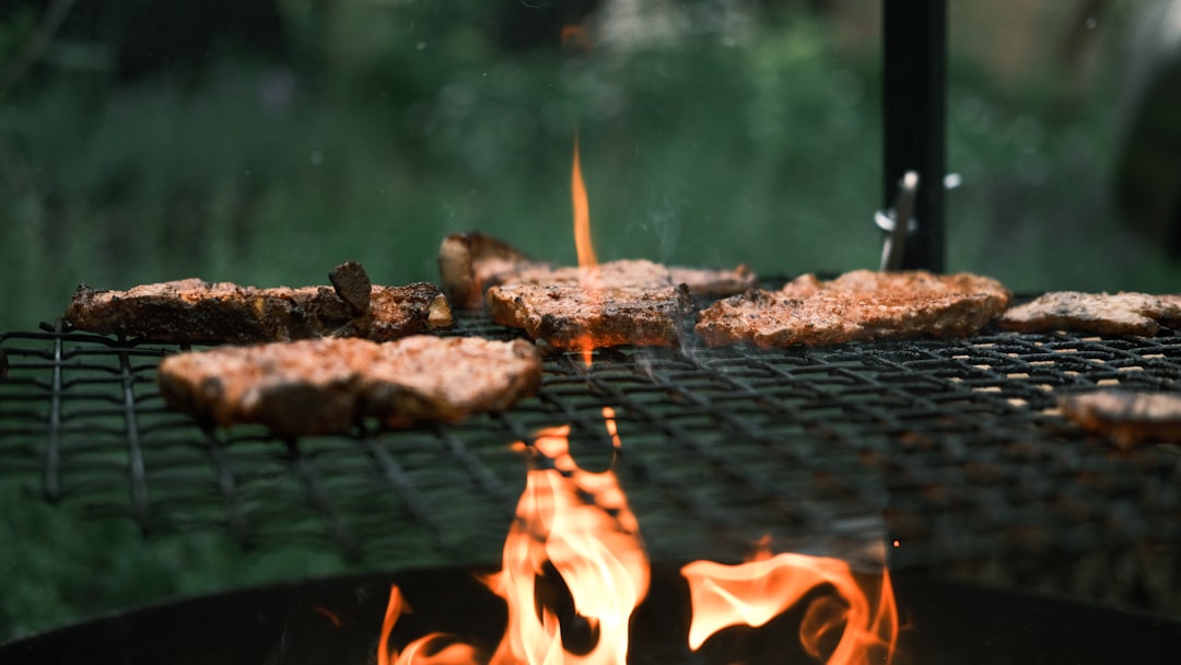 Thermomètre posé sur le couvercle d'un barbecue à charbon en cours de cuisson