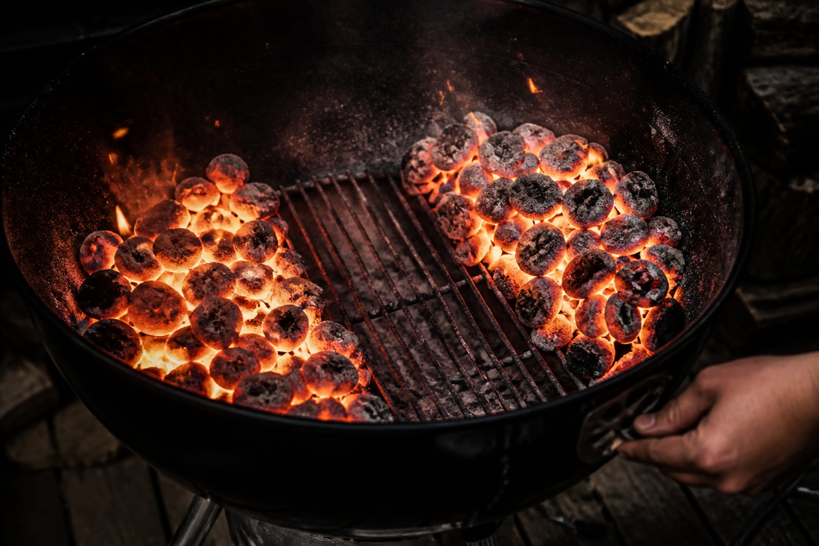 Braises rougeoyantes réparties dans une cuve de barbecue à charbon, entrées d'air ouvertes