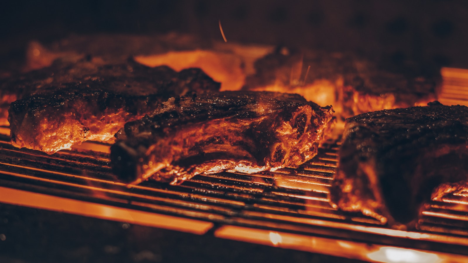 Pièce de bœuf en cuisson sur la grille d'un barbecue