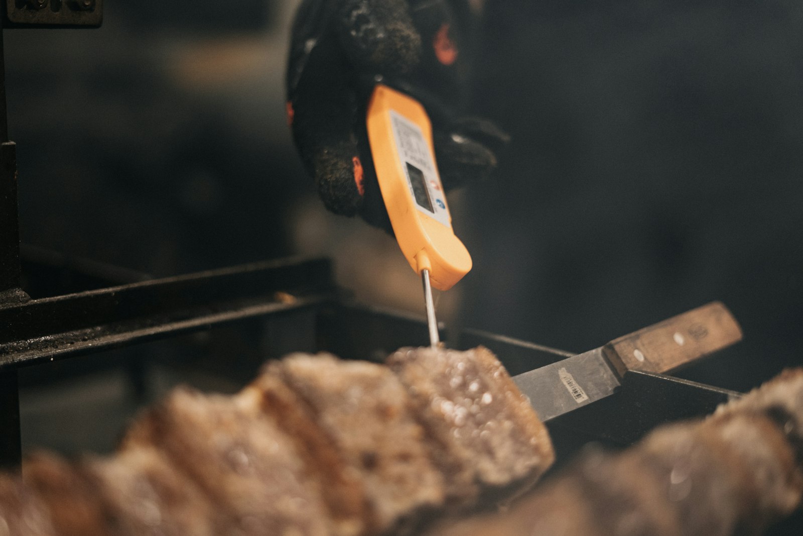Thermomètre à sonde planté dans une viande en cuisson sur un barbecue