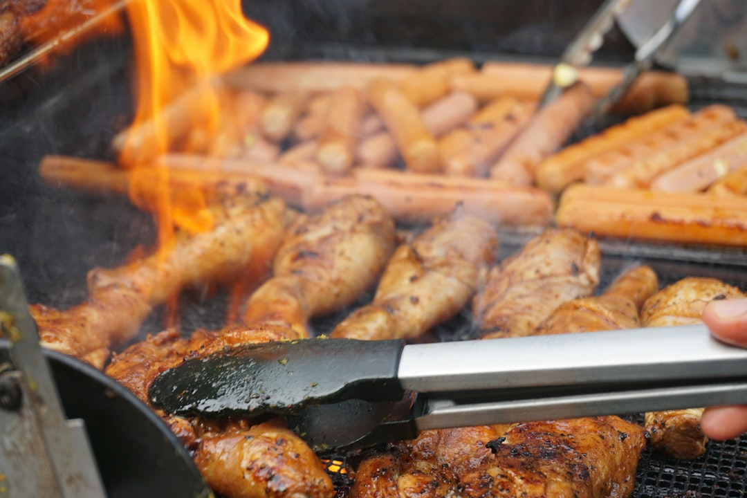 Morceaux de poulet mariné en cuisson sur la grille, peau dorée.